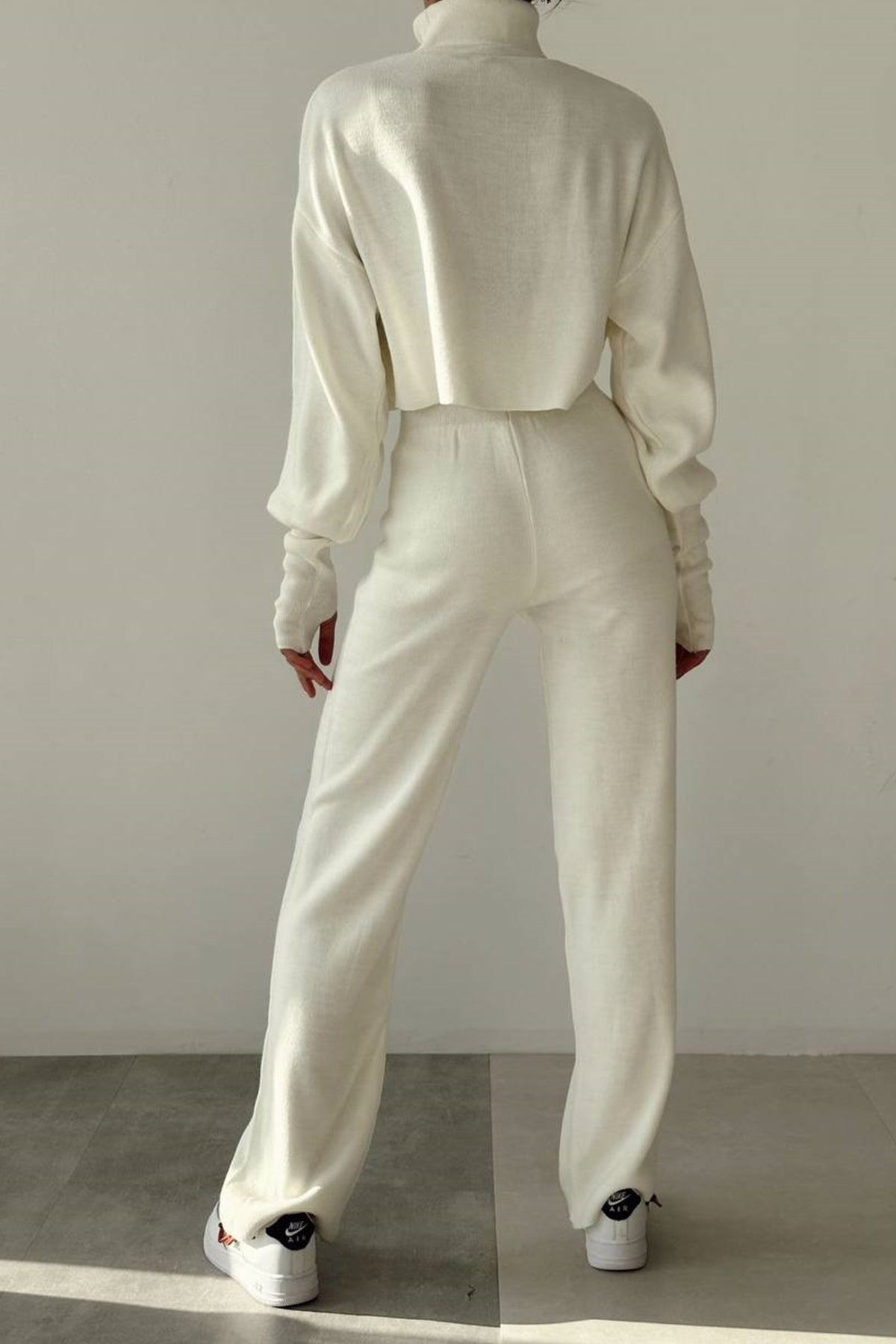 Rollkragenpullover und hochgeschnittene Strickhose (Oberteil und Hose).