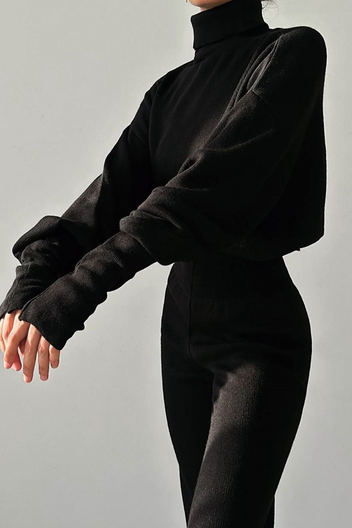Rollkragenpullover und hochgeschnittene Strickhose (Oberteil und Hose).