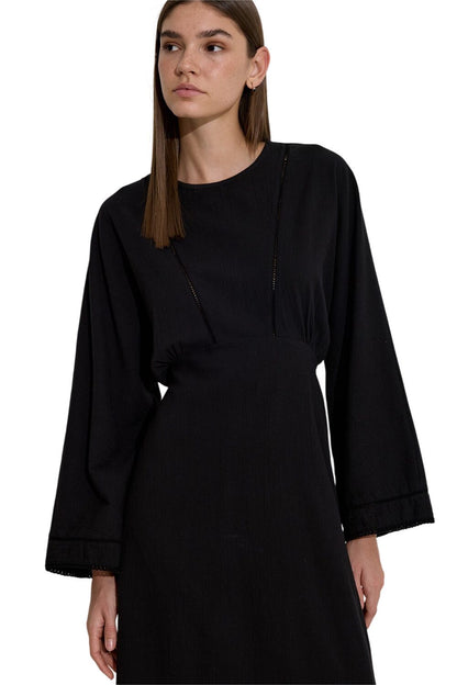 SCHWARZES KLEID MIT STREIFENVERKLEIDUNG IN STRUKTUR.