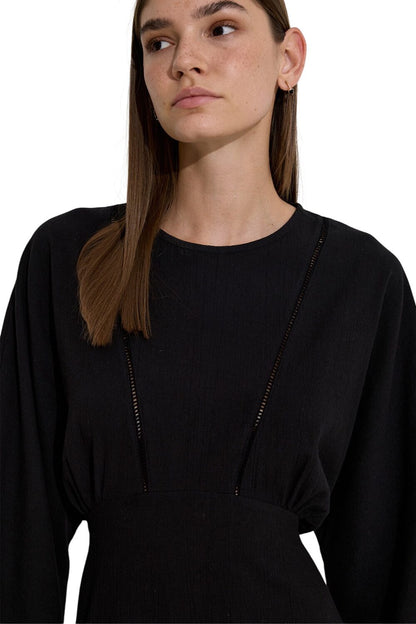 SCHWARZES KLEID MIT STREIFENVERKLEIDUNG IN STRUKTUR.