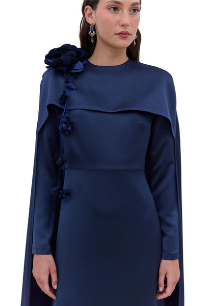 SCHWARZES ABENDKLEID MIT CAPE UND BLUMENVERZIERUNGEN.