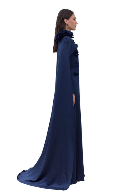 SCHWARZES ABENDKLEID MIT CAPE UND BLUMENVERZIERUNGEN.