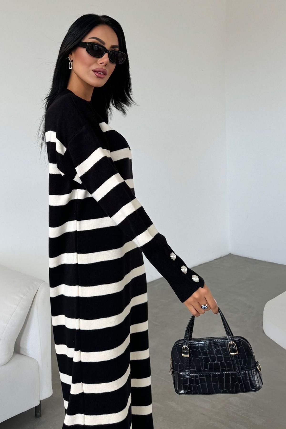 Langärmeliges, gestreiftes Strickkleid in Midi-Länge mit Rundhalsausschnitt und Knopfdetails an den Ärmeln.
